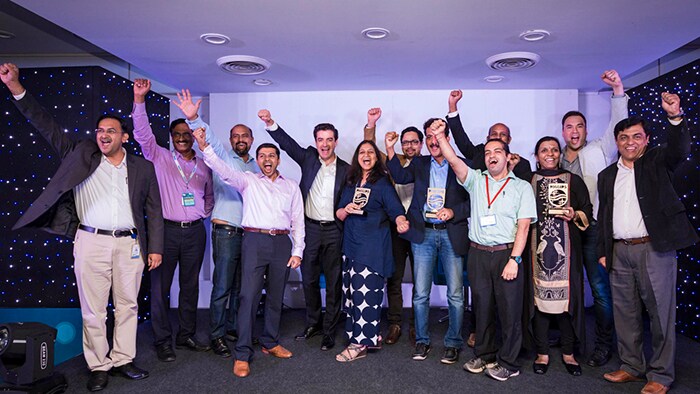 Smiling innovators at Breakthrough Day pose for the camera holding signs with hashtags — “#PhilipsHealthworks” and “#BTday.”