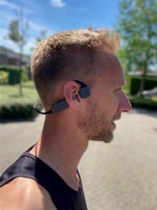 Mandlig løber med bone-conduction-hovedtelefoner
