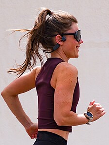 Kvindelig løber med bone-conduction-hovedtelefoner