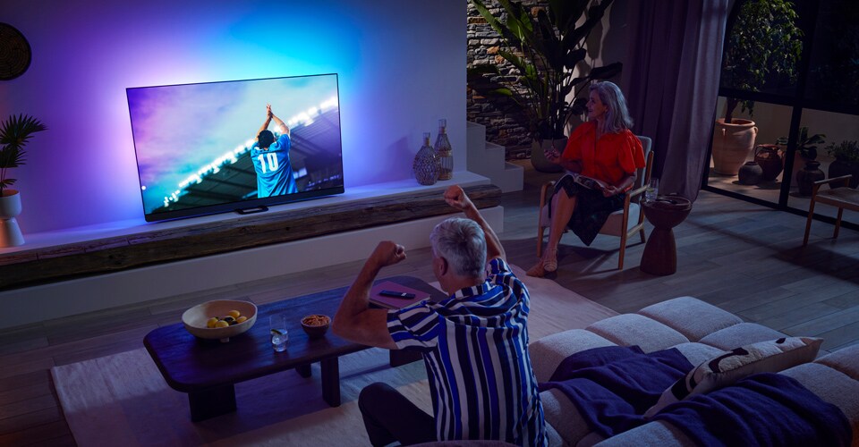 Familien ser en kamp på et OLED-TV