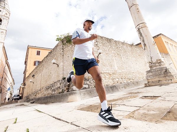 En deltager i løbet løber selvsikkert i en gammel by