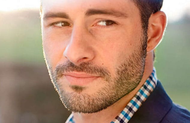 Et nærbillede af en brunhåret mand med lyse skægstubbe.